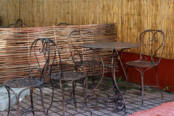 Chairs and tables in cozy outdoor cafe at summer