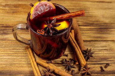 Ahşap masada sıcak şarap ve baharatlar.