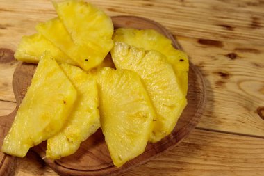 Tahta masadaki kesme tahtasındaki ananas parçaları. Üst görünüm