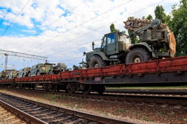 Tren düz vagonlarda askeri araçlar taşıyan kargo treni.