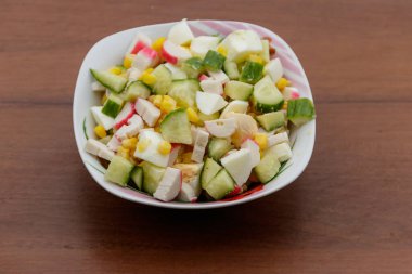 Yengeç sopa, tatlı mısır, salatalık ve ahşap masa üzerinde yumurta salatası. Üstten Görünüm