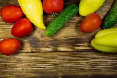 Domates, salatalık ve biber kopya alanı ile ahşap arka plan üzerinde. Üstten Görünüm