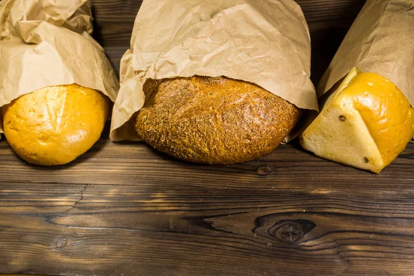 Assortiment Brood Verpakt Papier Houten Tafel Bovenaanzicht Kopieer Ruimte — Stockfoto