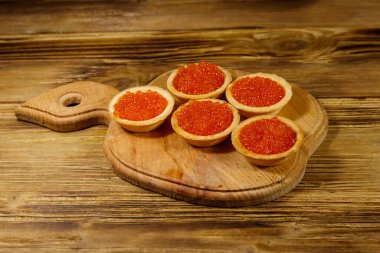 Tahta bir masada kırmızı havyarlı turta.