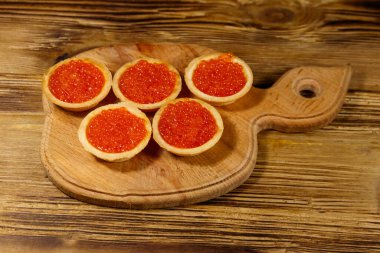 Tahta bir masada kırmızı havyarlı turta.