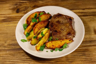 Tahta masada patates dilimli kızarmış biftek.