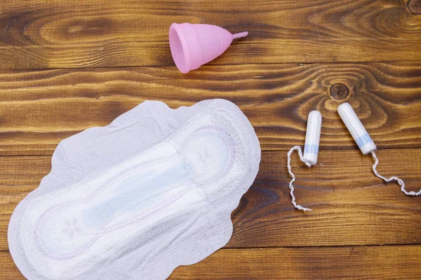 Bantalan Menstruasi Tampon Dan Cangkir Menstruasi Pada Latar Belakang Kayu — Stok Foto