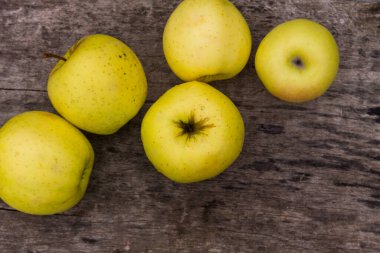 Kırsal ahşap masada olgun yeşil elmalar