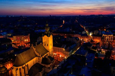 Ukrayna, Lviv 'deki Aydınlatılmış Latin Katedrali ve Rynok Meydanı' nın gece görüşü. Lviv belediye binasından görüntü