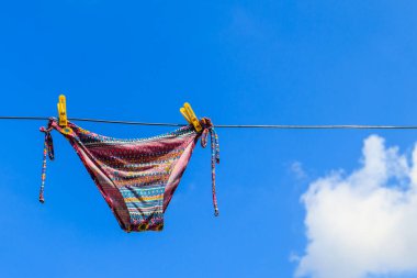 Kadın mayo mavi gökyüzü karşı bir ip asılı kurutma. Yaz tatil kavramı