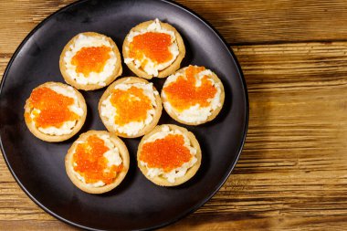 Kırmızı havyarlı turta ve ahşap bir masada yumuşak peynir. Üst görünüm