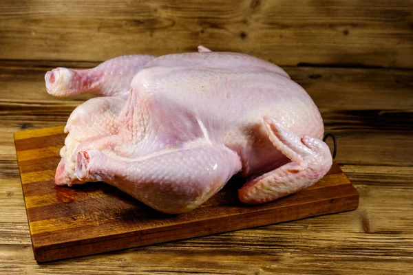 把整只鸡放在木制桌子上 — 图库照片