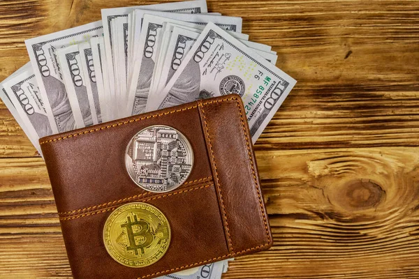 Ahşap arka plan üzerinde Amerikan yüz dolar faturaları ve bitcoins ile Cüzdan