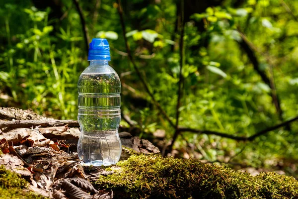 Plastikowa Butelka Słodką Wodą Pitną Zielonym Tle Lasu — Zdjęcie stockowe