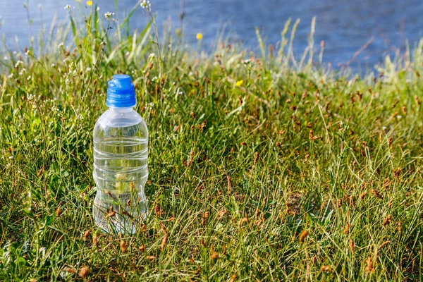 Plastikowa Butelka Świeżą Wodą Pitną Zielonej Trawie Brzegu Rzeki — Zdjęcie stockowe