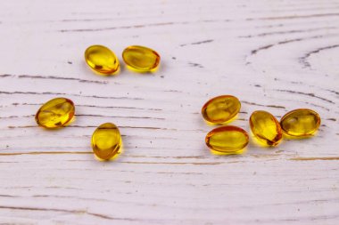 Beyaz ahşap bir masada Omega 3 hapları.