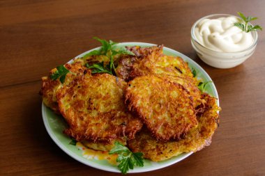 Ahşap masada ekşi kremalı ev yapımı patates krepleri.