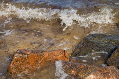 Kayaların üzerinden süzülen deniz dalgaları