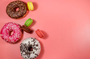 Pembe arka planda lezzetli çörekler ve kurabiyeler. Üst görünüm, alanı kopyala