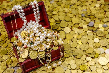 Altın sikke ve mücevherlerle dolu eski bir hazine sandığı.