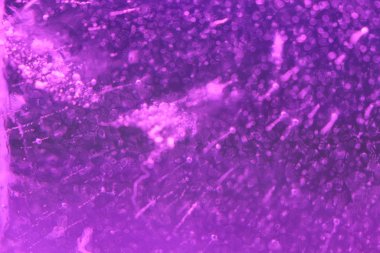 Aydınlatılmış mor buz dokusunun içinde hava kabarcıkları olan soyut arkaplanı