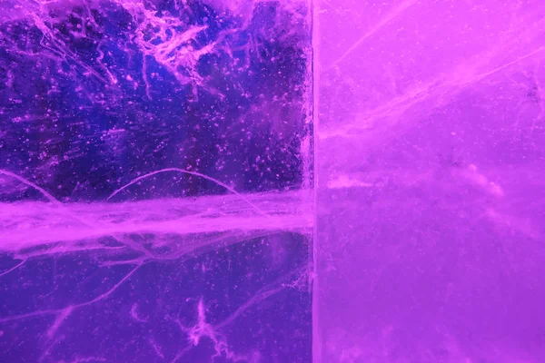 Aydınlatılmış şeffaf şeffaf renkli buz dokusunun soyut arkaplanı ikiye bölünmüş