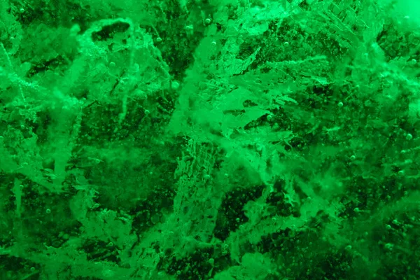 Fondo abstracto de textura de hielo verde iluminado con grietas y burbujas en el interior —  Fotos de Stock