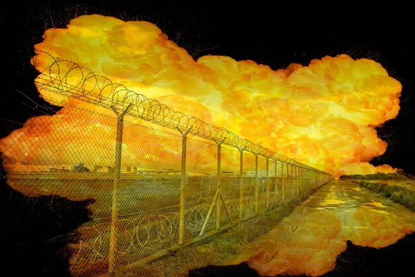 Realistic orange fire explosion behind restricted area barbed wire fence — Stock Photo, Image
