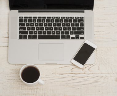 Laptop klavye, telefon ve bir fincan kahve Beyaz ahşap zemin üzerinde