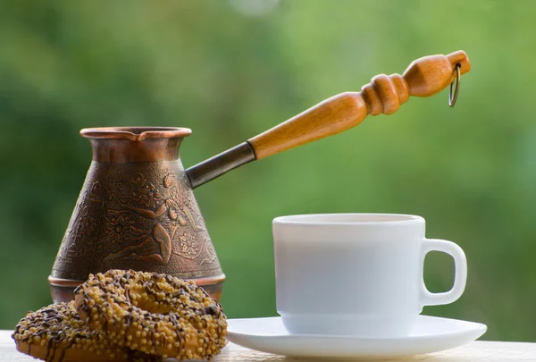 Mug coffee, cookies and copper pots outdoors on green background — Stock Photo, Image