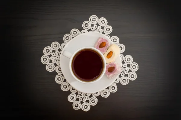 Top view of a cup of coffee and Turkish delight with almonds on a saucer, lace doily — Stock Photo, Image