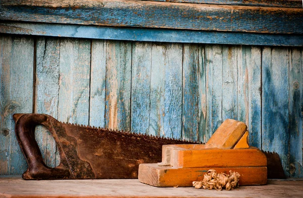 Alte Säge, Hobelmaschine und Späne auf blauem Holzgrund — Stockfoto