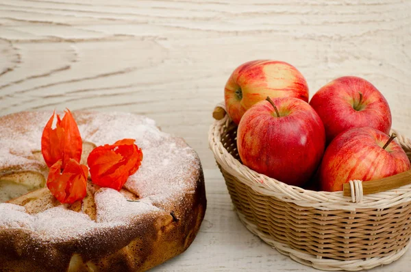 Apple pie, Physalis flowers and ripe apples on a light wooden table, close-up — Stock Photo, Image