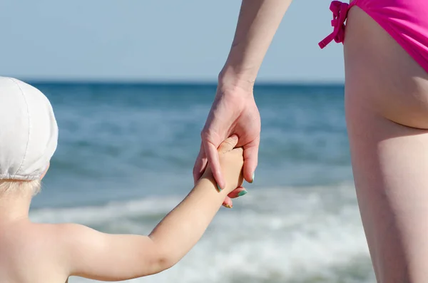 Madre mantiene hijo por la mano en un fondo del mar, primer plano — Foto de Stock