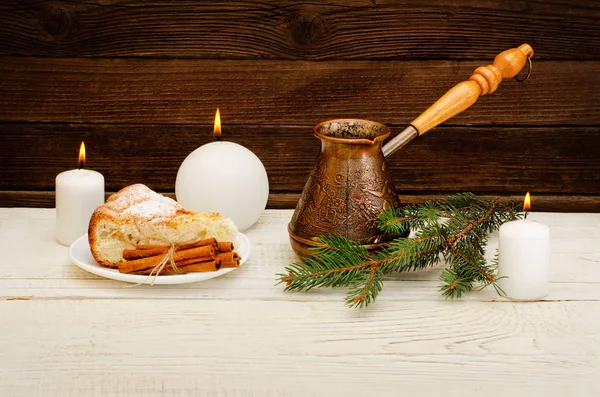Горщики кави, ялинова гілочка, яблучний пиріг, палички кориці та свічки на дерев'яному фоні — стокове фото