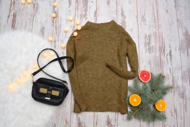 Yün kazak ve çanta ahşap arka plan üzerinde. Garland, portakal ve Ladin şube. Moda kavramı, üstten görünüm