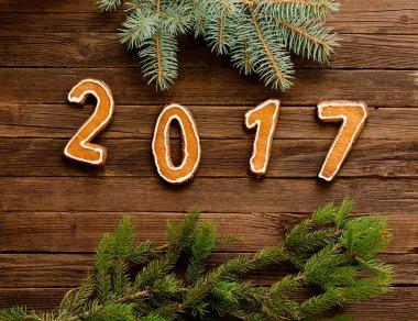 Yeni yıl kavramı. 2017 gingerbread ahşap arka plan üzerinde çerçevenin kenarındaki kürk-ağaç dalı şekilde