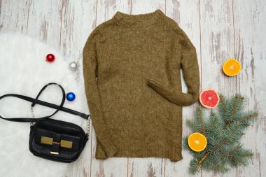 Yün kazak ve çanta ahşap arka plan üzerinde. Turuncu, Ladin şube ve Noel topları. Moda kavramı, üstten görünüm