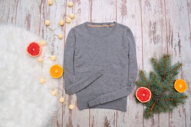 Ahşap arka plan üzerinde gri yün kazak. Portakal ve greyfurt, çeki düzen vermek şube, Garland. Moda kavramı, üstten görünüm