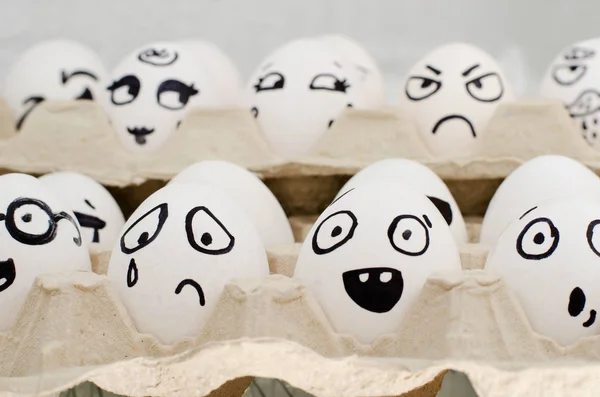 Huevos en bandeja pintados con diferentes emociones: tristeza, sorpresa, asombro. Primer plano — Foto de Stock