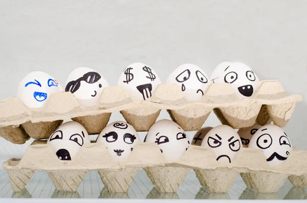 Deux plateaux avec des œufs sur l'étagère du réfrigérateur, peints émotions différentes : tristesse, surprise, joie, peur — Photo