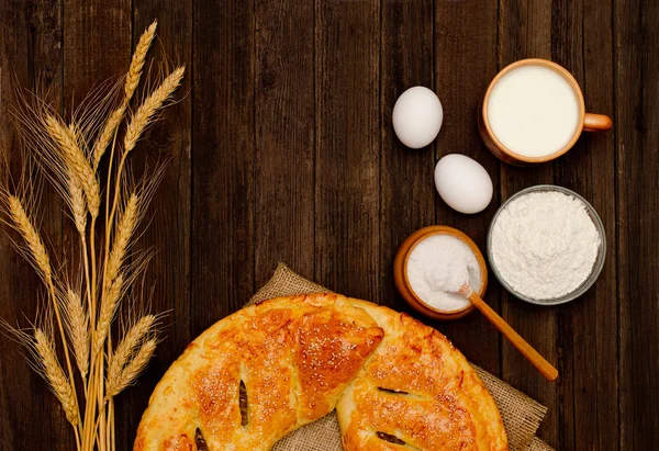Pasta, pişirme, kulakları buğday için malzemeler ve süt ahşap arka plan üzerine bir fincan. Metin için yer. — Stok fotoğraf
