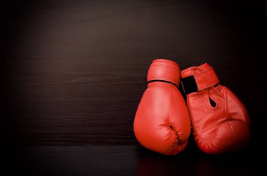 Tarafında siyah bir arka plan boş boşluk karede iki kırmızı boks eldivenleri
