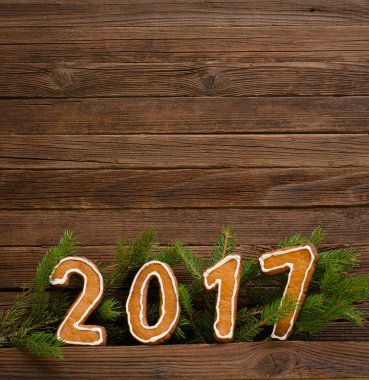 Yeni yıl kavramı. Şekil 2017 gingerbread, köknar dalı ahşap arka plan, metin için yer