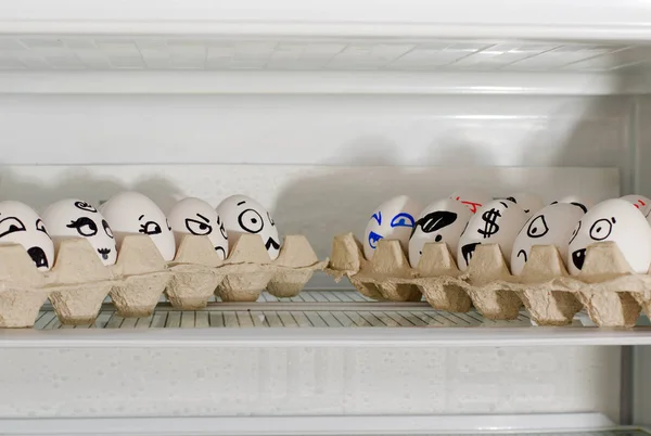 Dos bandejas de huevos con sonrisas uno frente al otro en un estante en el refrigerador — Foto de Stock