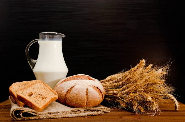 натюрморт с яйцами и молоком. depositphotos 134775586 stock photo jug of milk round rye. натюрморт с яйцами и молоком фото. натюрморт с яйцами и молоком-depositphotos 134775586 stock photo jug of milk round rye. картинка натюрморт с яйцами и молоком. картинка depositphotos 134775586 stock photo jug of milk round rye. Стакан молока, буханка и сноп на черном фоне, с местом для текста