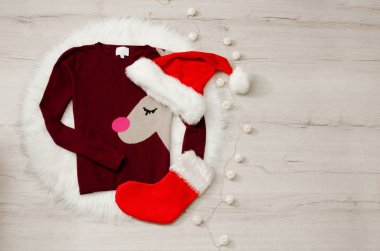 Yeni bir kavram, geyik ile kazak ve çorap bir Noel Baba şapkası. Garland, ahşap arka plan, metin için yer