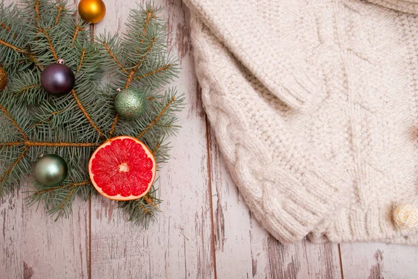 Різдвяна концепція в'язаного светра, гілка ялинки з ялиновими кульками, грейпфрут. вид зверху — стокове фото