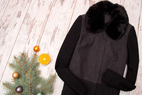 Conceito na moda, casaco de lã preta com pele, ramo de abeto e laranja — Fotografia de Stock