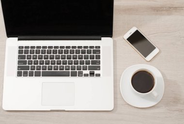 Bir dizüstü bilgisayar, akıllı telefon ve bir fincan kahve Üstten Görünüm